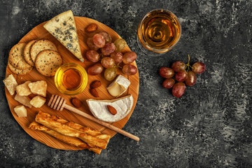 Assortment of cheese with honey, nuts and grape 