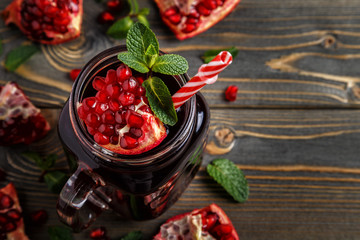 Glass of pomegranate juice with fresh pomegranate fruits