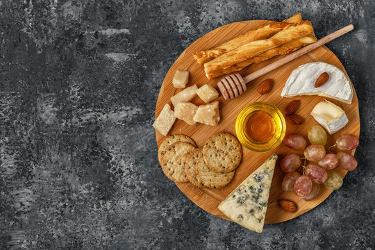 Assortment of cheese with honey, nuts and grape 