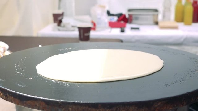 Pancake batter gets poured onto a hot plate