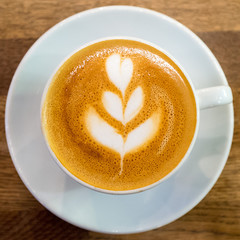 Latte art by a professional barista from a top-down view.