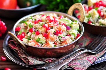 Healthy salad with couscous, tomato, avocado, red onion, pomegranate and olive oil. Eastern cuisine.