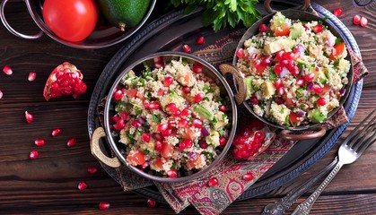 Healthy salad with couscous, tomato, avocado, red onion, pomegranate and olive oil. Eastern cuisine.