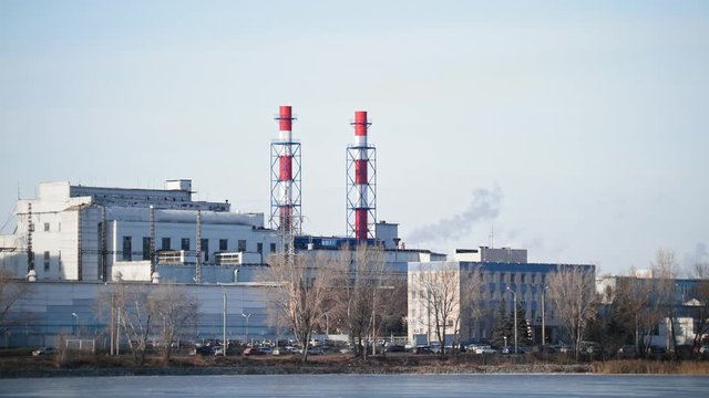 Industrial landscape - power plant at sunny day, white vapor from red tube
