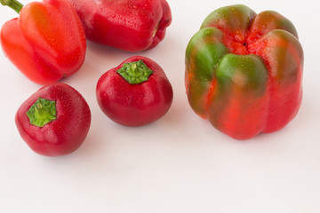 Red peppers  with water droplets on a white background.