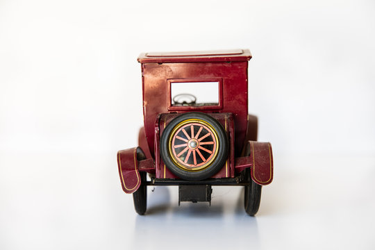 Old vintage tin toy Model A car back view with white background.