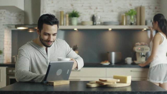  Couple in The Kitchen. Woman Cooks while Man Uses Tablet. Shot on RED Cinema Camera in 4K (UHD).