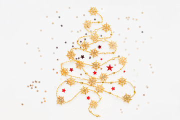Christmas Tree made of golden snowflake garland with silver star confetti. New Year symbol with place for text. Flat lay, top view.