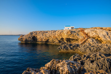 Fototapeta na wymiar Church on the rocky shore of Mediterranean Sea