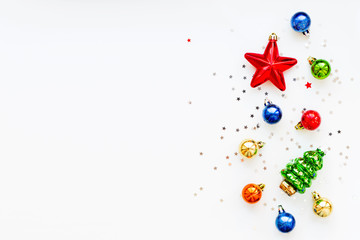 Christmas background with decorations. New Year symbol - fir tree. Shiny colorful balls, star and confetti. Flat lay, top view. Place for text.