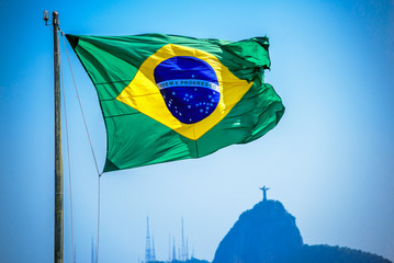 Brazilian flag on the background of Christ the Redeemer, Art Deco statue of Jesus Christ in Rio de...