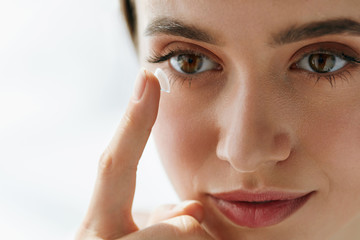 Closeup Of Beautiful Woman Applying Eye Lens In Eye