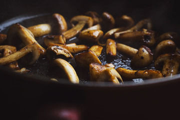 Roasted button mushrooms in a hot black frying pan