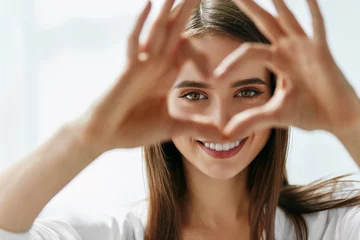 Foto op Aluminium Beautiful Happy Woman Showing Love Sign Near Eyes. © puhhha