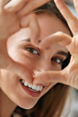 Beautiful Happy Woman Showing Love Sign Near Eyes.