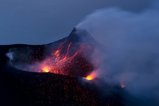 Lava and lapilli erupting from volcano at night, Lipari islands, Italy