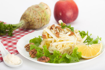 Waldorf salad with red apple, celery and walnuts over white background