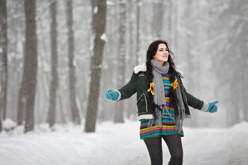 Beautiful young woman in a sweater on a winter walk in a park