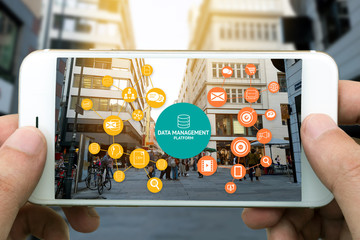Data Management Platform (DMP) , Marketing and crm concept. Hand holding smart phone , infographic , texts and icons on retail shopping store city shop background.