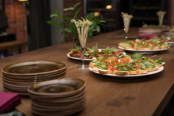 Foto auf Acrylglas Vorspeise Тарелка с закусками стоит на деревянном столе