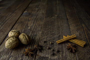 walnut anise cinnamon sticks and pepper on a wooden background