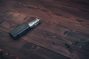e-cig mod or electronic cigarette for vaping on a wooden table background