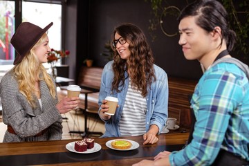 Smiling friends enjoying coffee and pastries