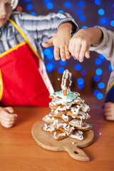 Children are prepared in the kitchen and decorate cookies on Christmas Eve