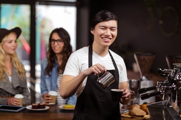 Smiling waiter making cup of coffee