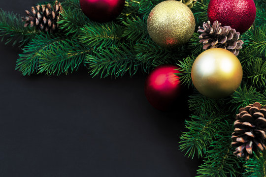 Christmas fir branches with decorations on a black background