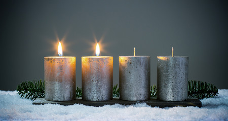 Zweite Advent - Vier silberne Adventskerzen mit zwei angezündeten Kerzen