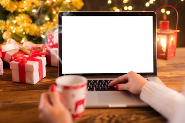 Woman working on laptop with Christmas background