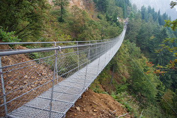 Fototapeta na wymiar Tibetan suspension metal bridge / Suspension metal bridge in Valli del Pasubio, Italy
