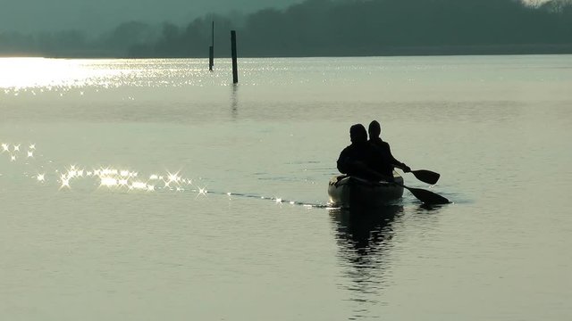 silhouette of a couple canoeing on a lake ammersee in germany
