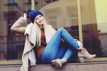 Outdoor full body portrait of young beautiful happy smiling girl posing on street. Model looking at...