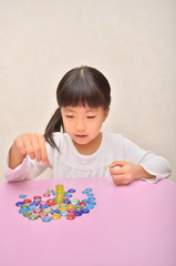 おはじきで遊ぶ女の子