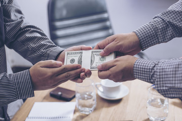 Giving a bribe into a pocket to negotiate business. Closeup shot