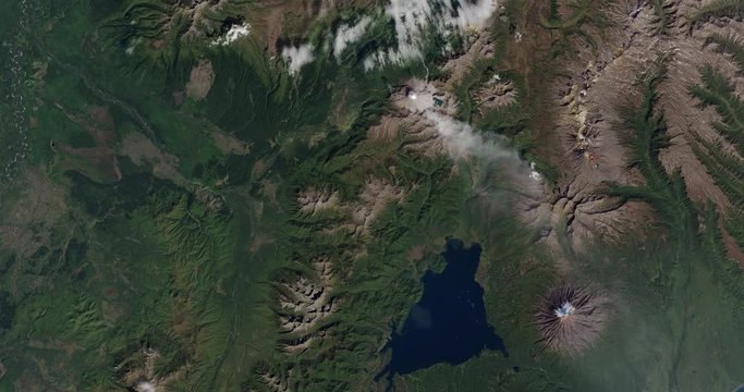 High-altitude overflight aerial of volcanic tundra on Russia's Kamchatka peninsula. Clip loops and is reversible. Elements of this image furnished by NASA 