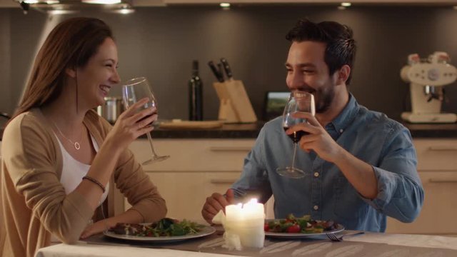  Beautiful Couple Having Candlelight Dinner in the Kitchen. They Eat, Drink and Talk. In Celebration they Clink Their Glasses. Shot on RED Cinema Camera in 4K (UHD).