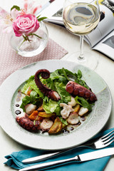 Octopus salad with arugula salad mix and wine