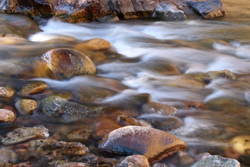 Icy water flows over rocks in the Poudre River in Colorado