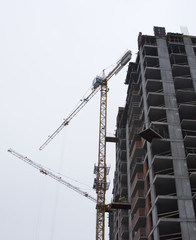Naklejka premium Residential buildings construction site with three working tower cranes