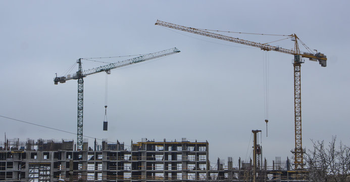 Residential buildings construction site with three working tower cranes