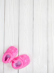 pink booties on wooden background
