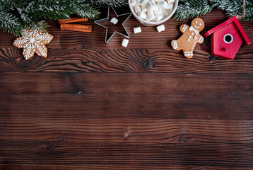Christmas gingerbread, spruce branches on dark wooden background top view