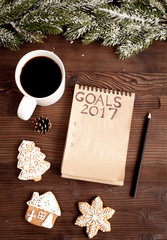 notebook and goals for new year wooden background top view