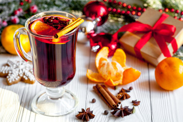 Christmas mulled wine with spices in cup on wooden background