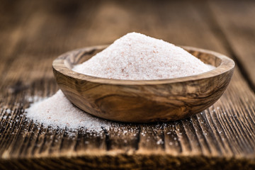 Portion of Himalayan Salt on wooden background (selective focus)