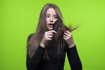 dry and damaged hair ends  girl holding magnifier, isolated on green screen