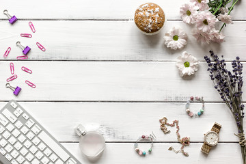 female wooden desktop with flowers top view